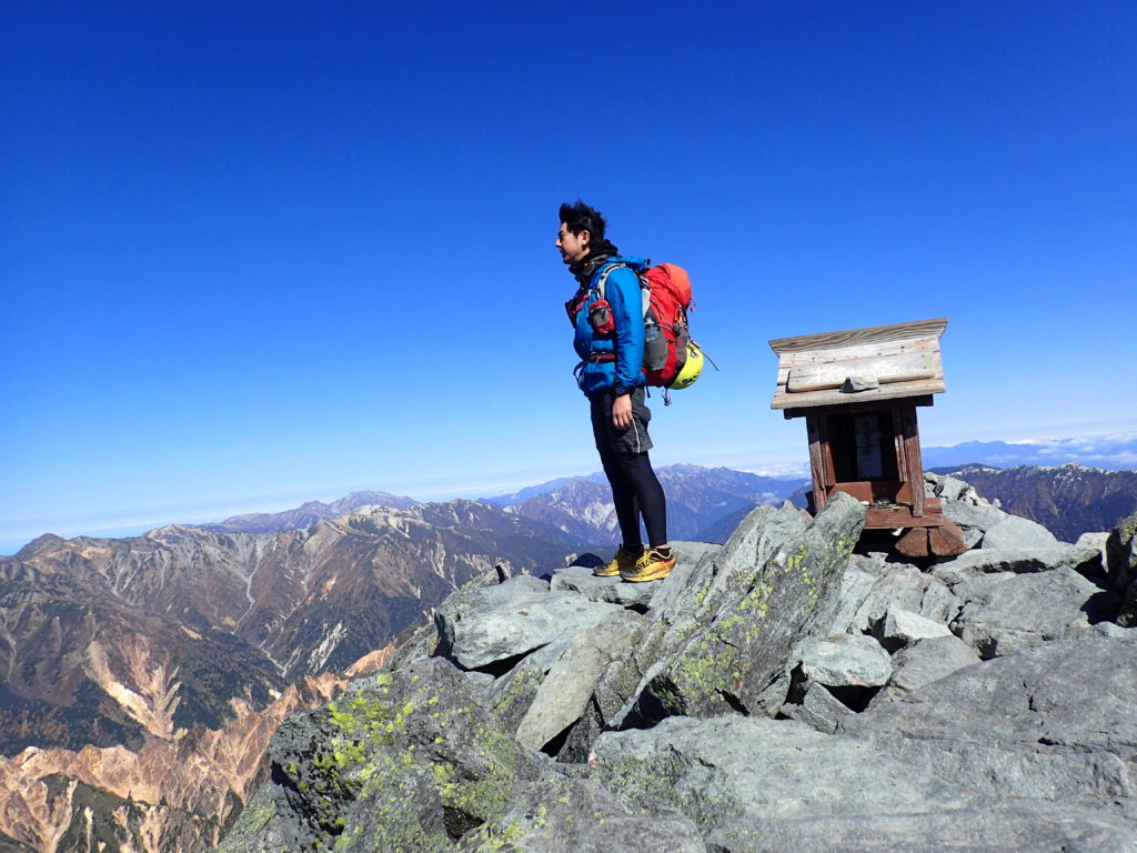 10月下旬の低温の槍ヶ岳山頂でモンベルの登山用レインウェアであるトレントフライヤーを着て記念撮影