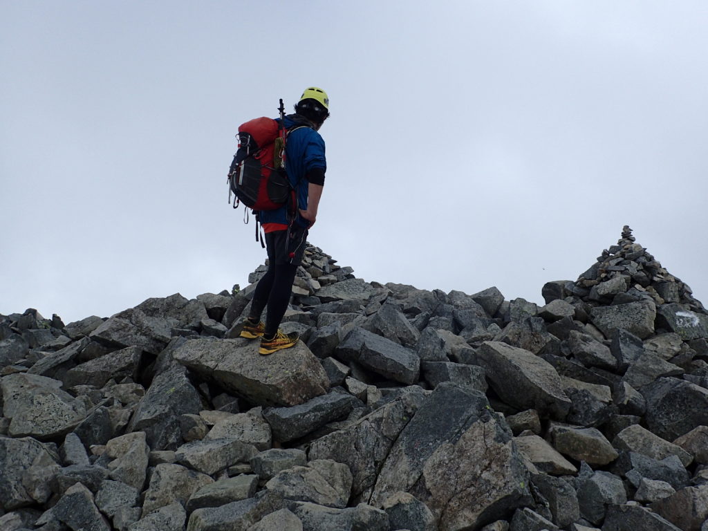 雨上がりの前穂高岳山頂でモンベルの登山用レインウェアであるトレントフライヤーを着て記念撮影