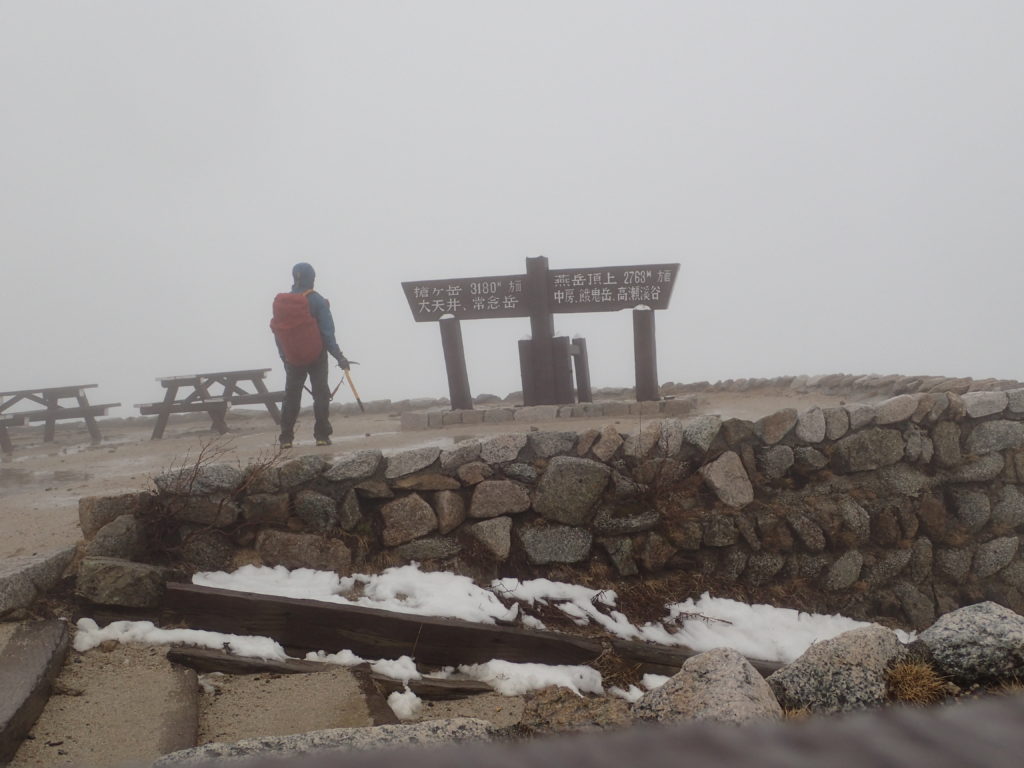 大雨の燕岳の燕山荘前でモンベルの登山用レインウェアであるトレントフライヤーを着ての記念撮影