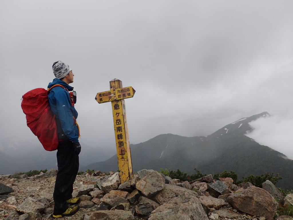 雨の爺ヶ岳山頂でモンベルの登山用レインウェアであるトレントフライヤーを着て記念撮影