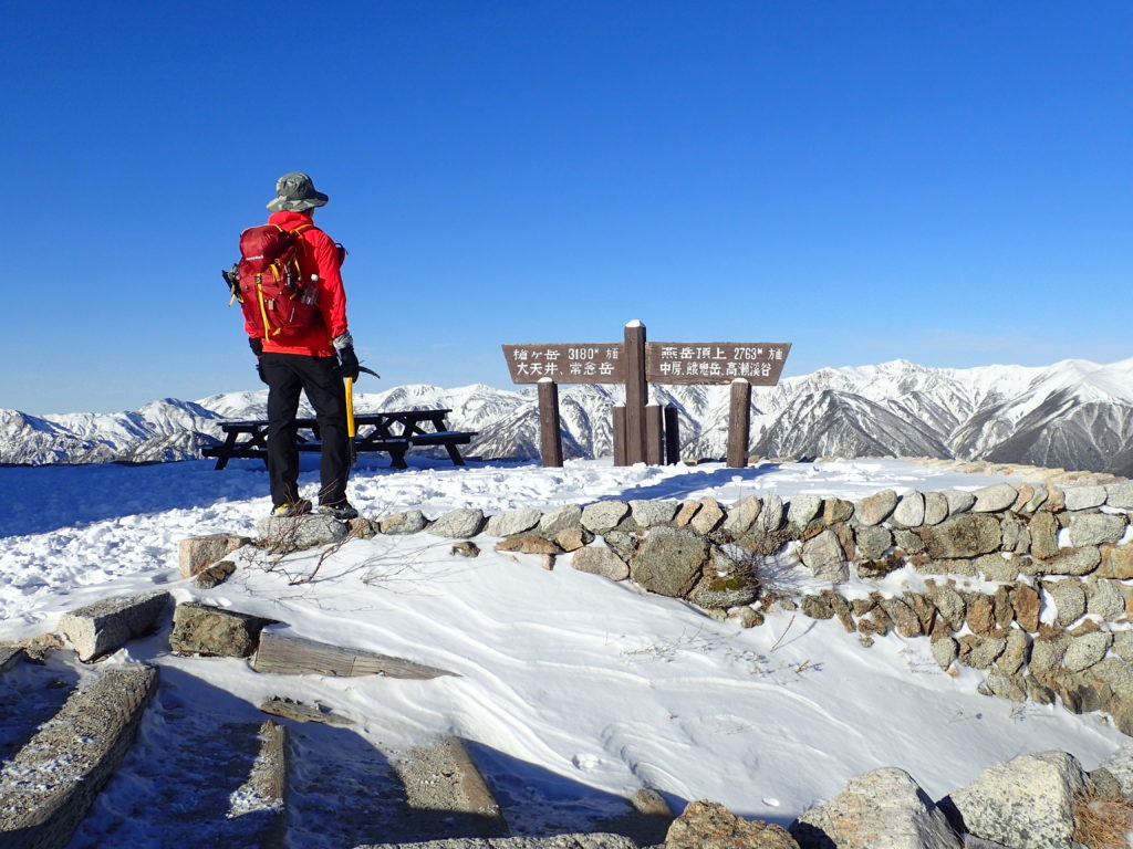 薄っすらと雪が積もった燕山荘前でモンベルの登山用ザックであるバーサライトパックを背負って記念撮影