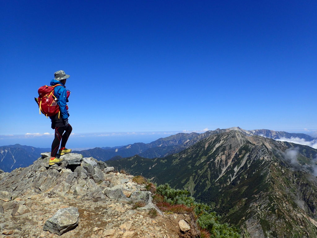 鹿島槍ヶ岳から五竜岳を眺める背中にモンベルの登山用ザックであるバーサライトパック