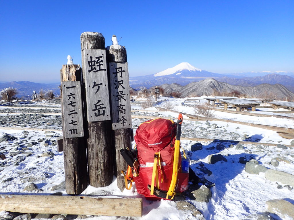 蛭ヶ岳山頂で雪化粧した富士山をバックにモンベルの登山用ザックであるバーサライトパックの記念撮影