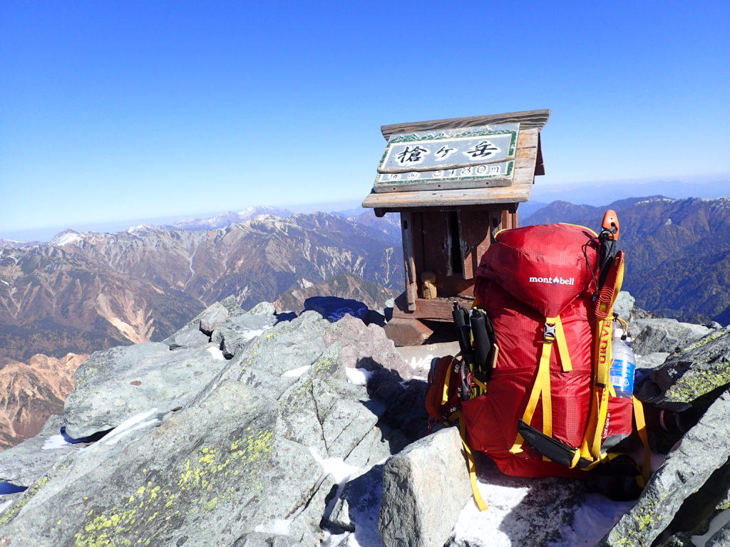 槍ヶ岳山頂の祠とモンベルの登山用ザックであるバーサライトパックの記念撮影