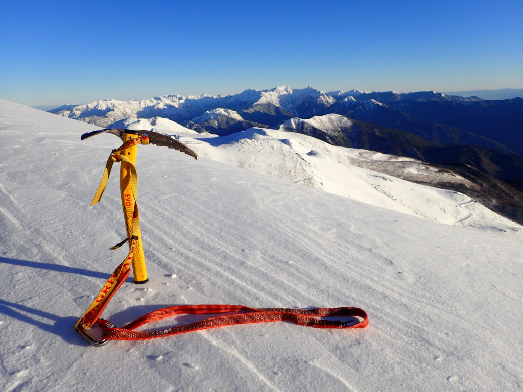 冬の乗鞍岳稜線で槍ヶ岳と穂高岳をバックにグリベルのピッケルであるエアーテックエヴォリューションの記念撮影