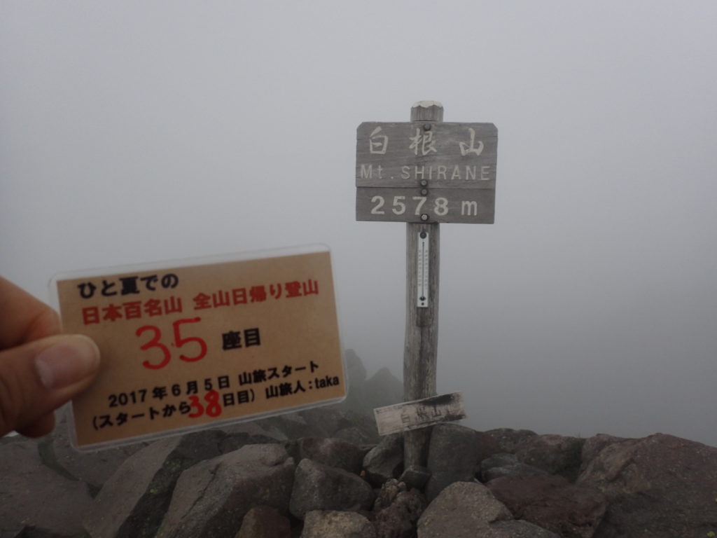 ひと夏での日本百名山全山日帰り登山で登った日光白根山の山頂で自作の登頂カードで記念写真