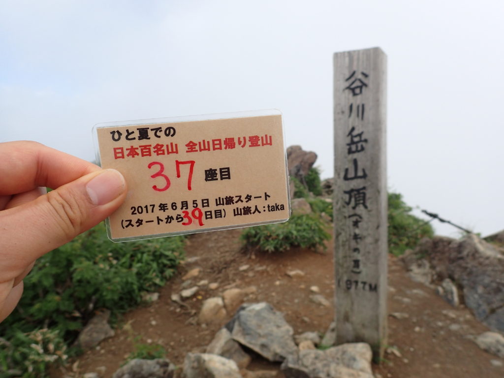 ひと夏での日本百名山全山日帰り登山で登った谷川岳の山頂で自作の登頂カードで記念写真