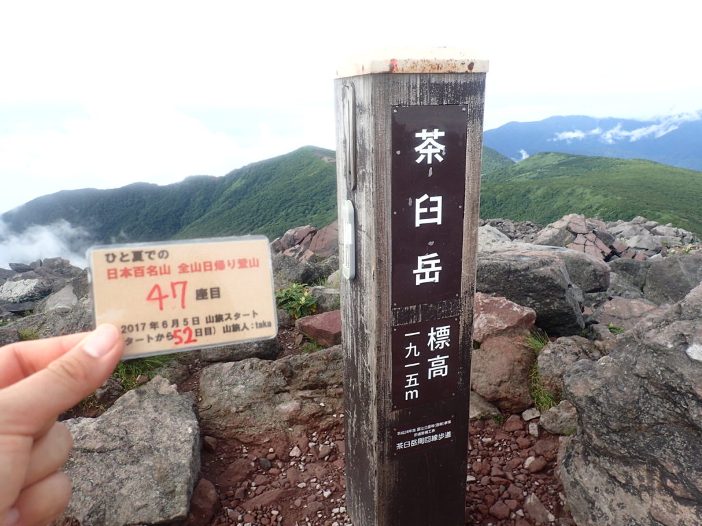 ひと夏での日本百名山全山日帰り登山で登った那須岳の茶臼岳の山頂で自作の登頂カードで記念写真