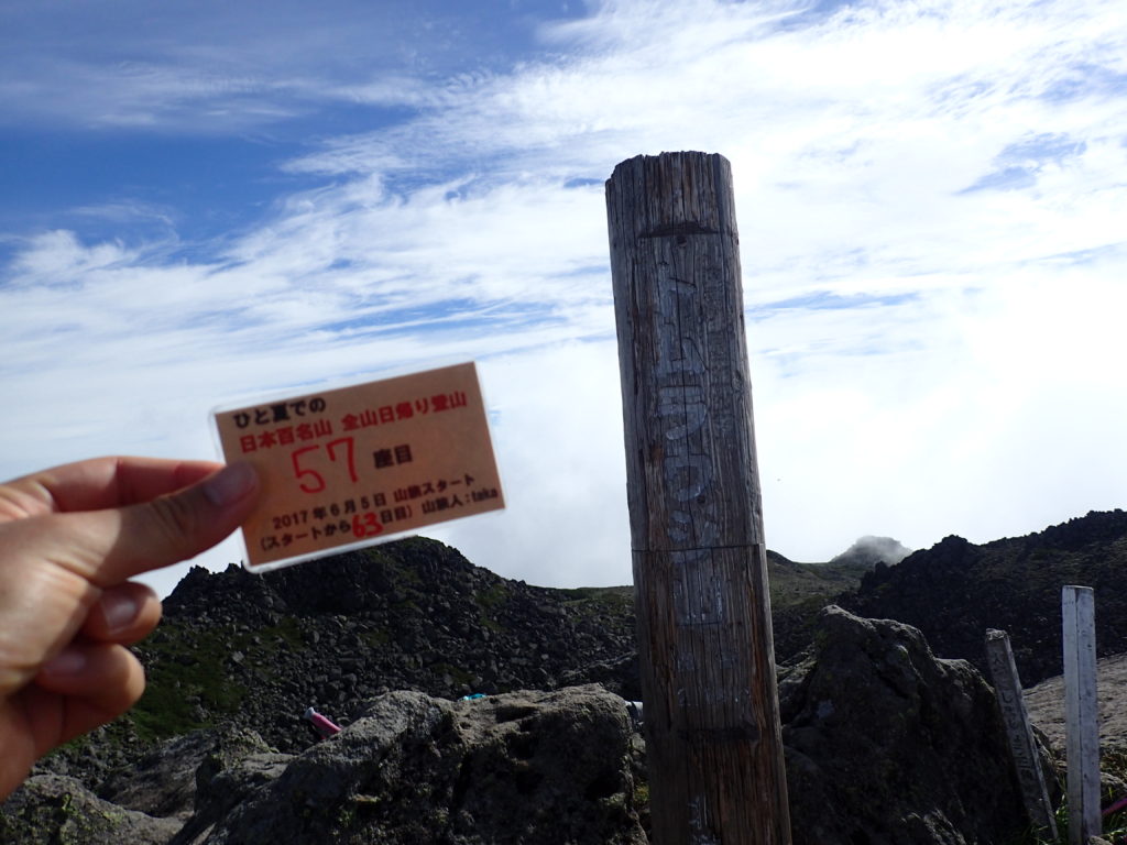 ひと夏での日本百名山全山日帰り登山で登ったトムラウシ山の山頂で自作の登頂カードで記念写真