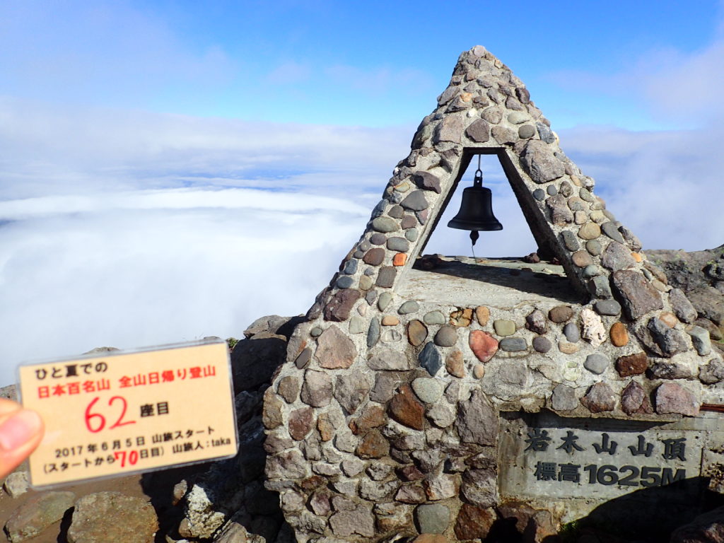 ひと夏での日本百名山全山日帰り登山で登った岩木山の山頂で自作の登頂カードで記念写真