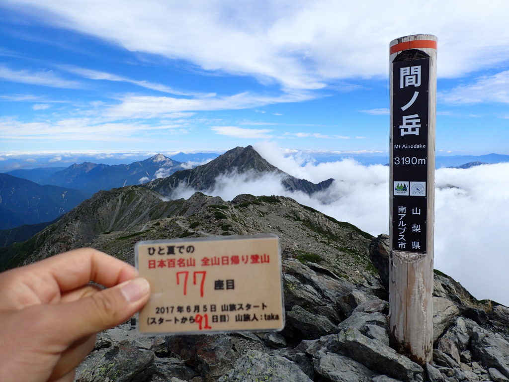 ひと夏での日本百名山全山日帰り登山で登った間ノ岳の山頂で自作の登頂カードで記念写真