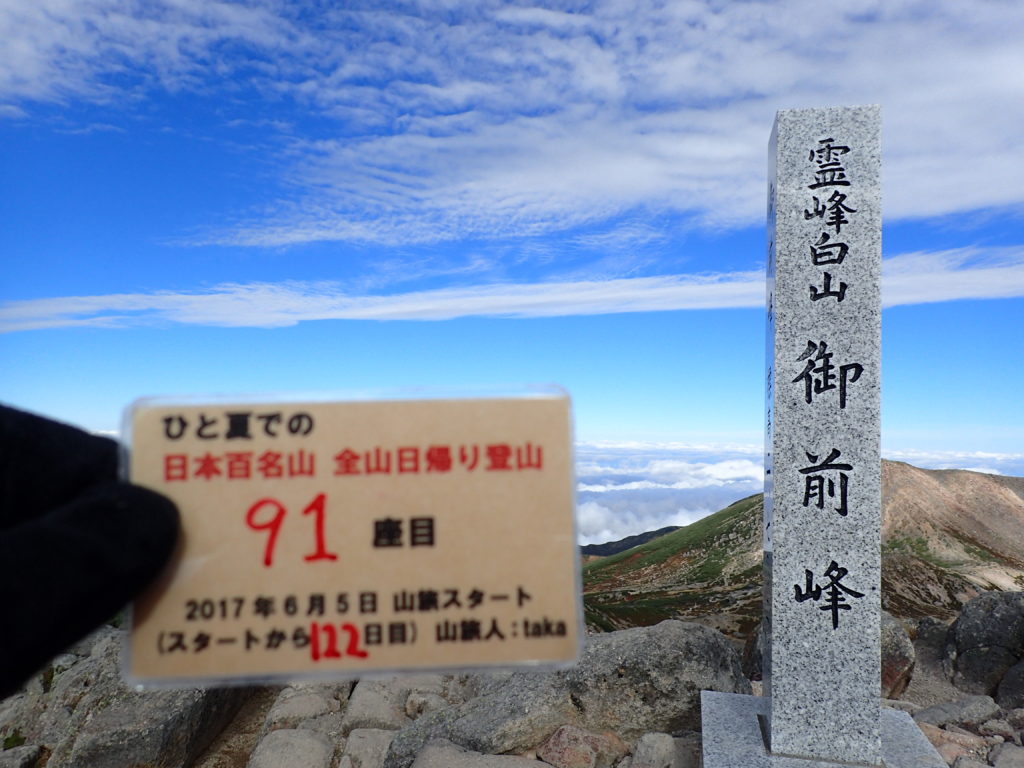 ひと夏での日本百名山全山日帰り登山で登った白山の御前峰の山頂で自作の登頂カードで記念写真