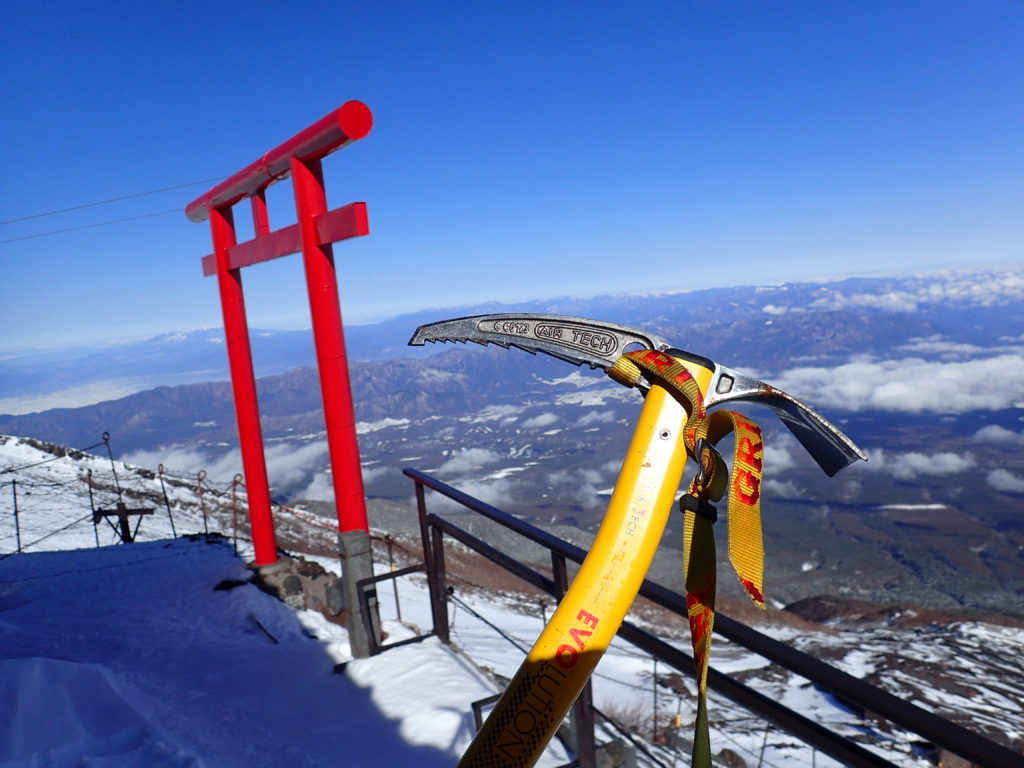 冬の富士山8合目の鳥居荘の鳥居を背景にグリベルのピッケルであるエアーテックエヴォリューションの記念撮影