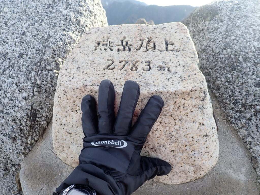 燕岳山頂の石碑でモンベルの登山用グローブであるサンダーパスグローブの記念写真を撮影