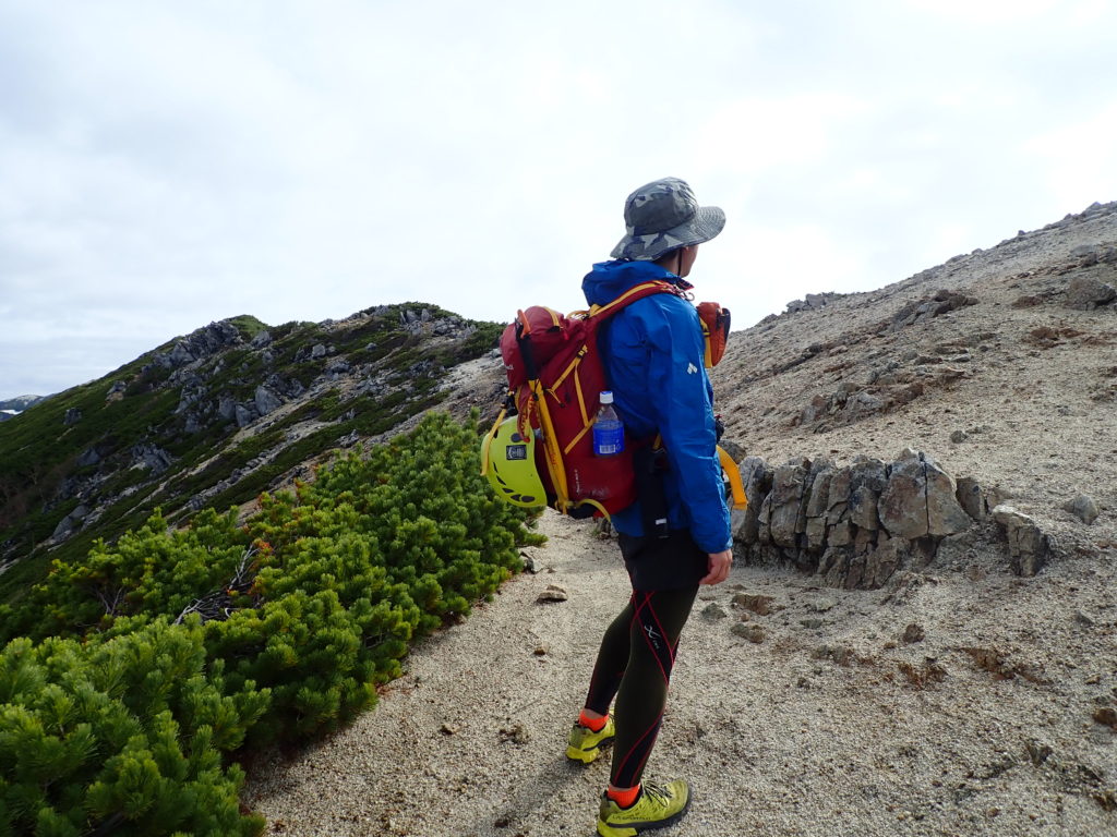 北アルプス表銀座の稜線でモンベルの登山用レインウェアであるトレントフライヤーを着て記念写真を撮影