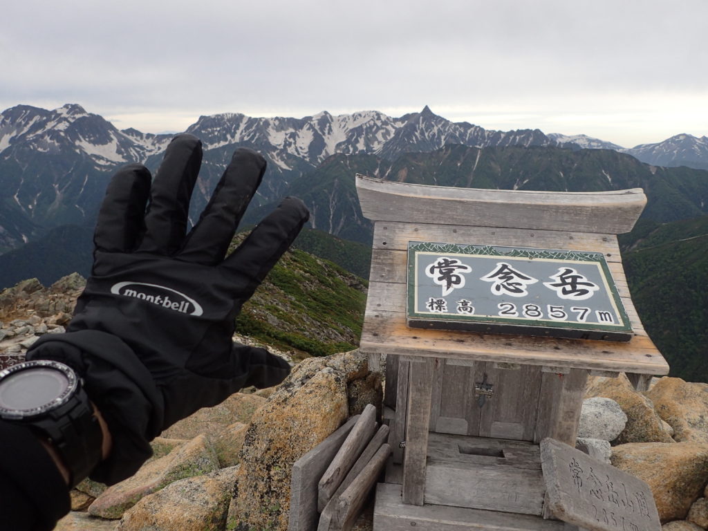 常念岳山頂で槍ヶ岳をバックにモンベルの登山用グローブであるサンダーパスグローブの記念写真を撮影