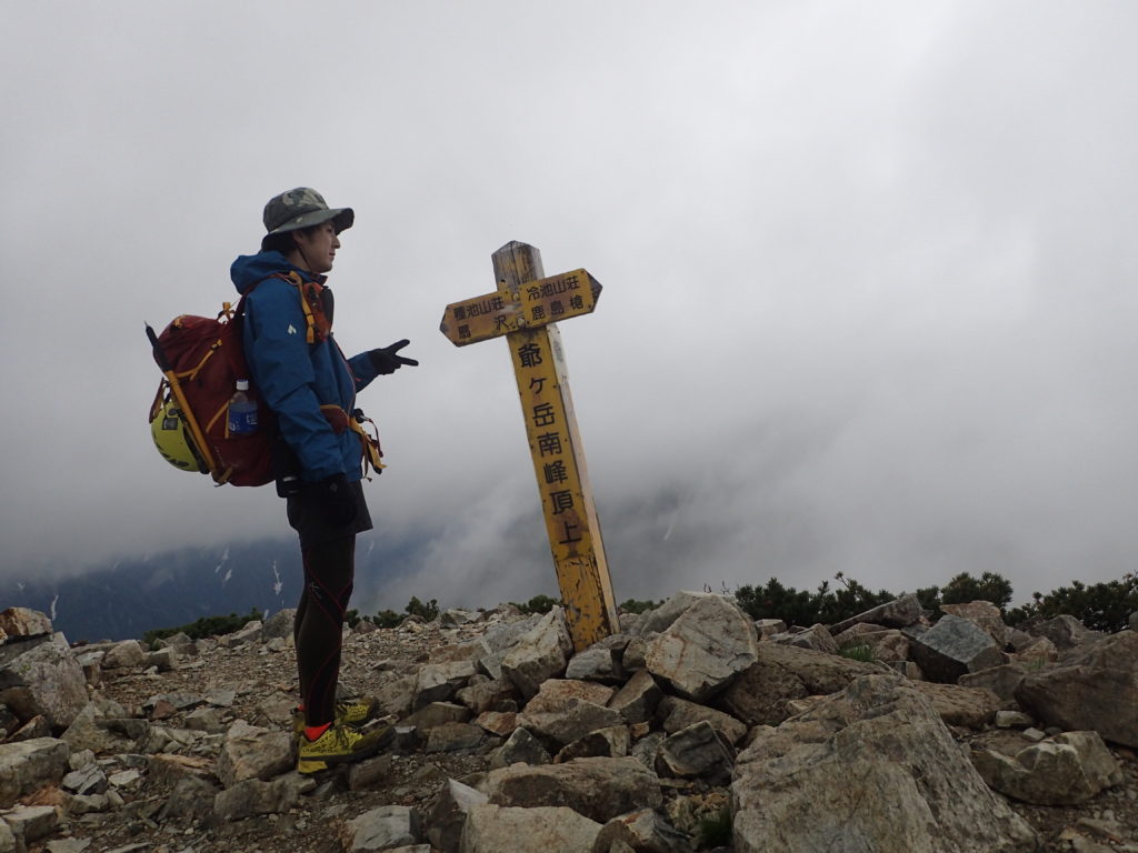 梅雨時で小雨の降る爺ヶ岳山頂でモンベルの登山用レインウェアであるトレントフライヤーを着て記念写真を撮影