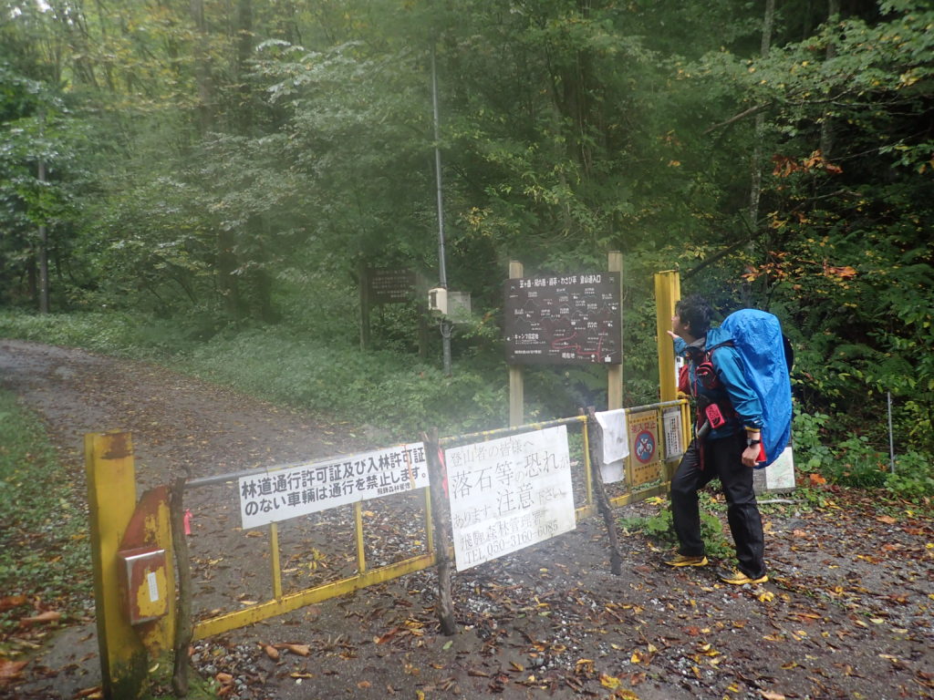 雨の新穂高左俣林道入口でモンベルの登山用レインウェアであるトレントフライヤーを着て記念撮影