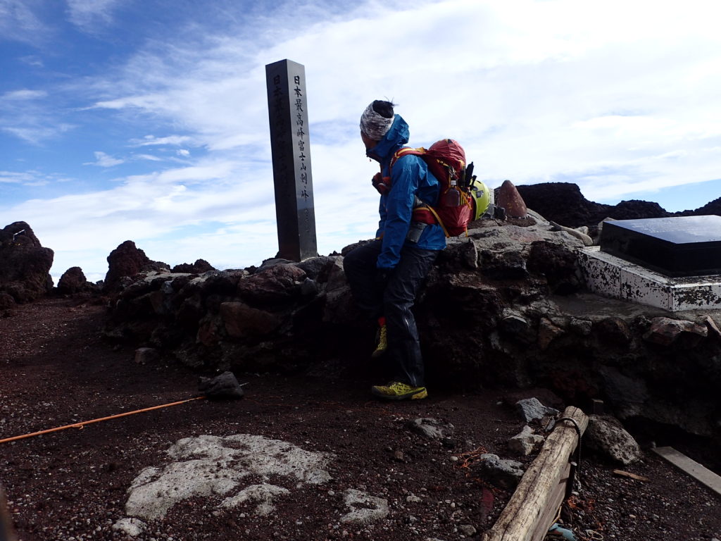 日本最高峰の富士山剣ヶ峰山頂でモンベルの登山用レインウェアであるトレントフライヤーを着て記念撮影