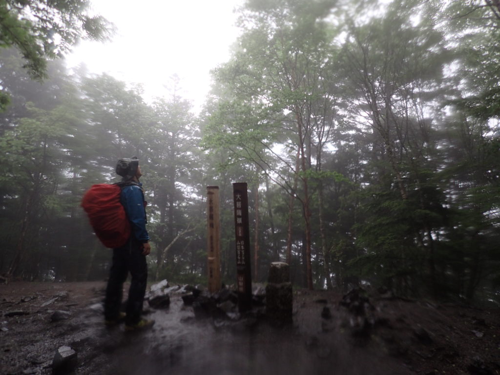 大雨の大菩薩嶺でモンベルのレインウェアであるトレントフライヤーを着て記念撮影