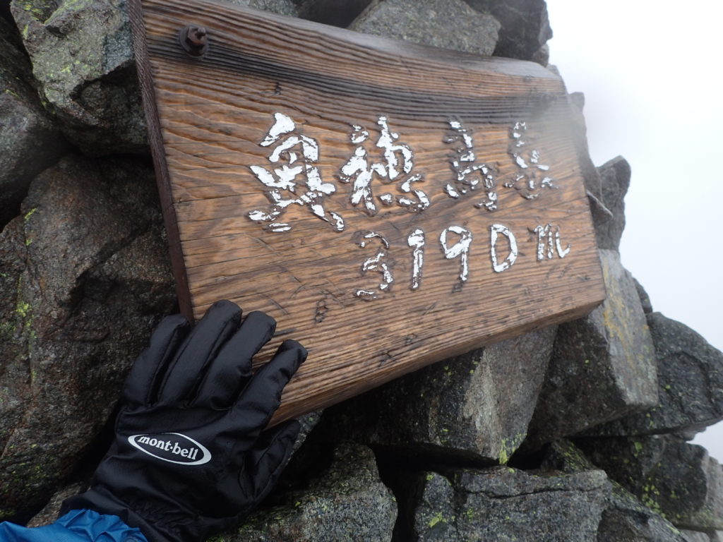 雨の奥穂高岳山頂でモンベルの登山用グローブであるサンダーパスグローブの記念撮影