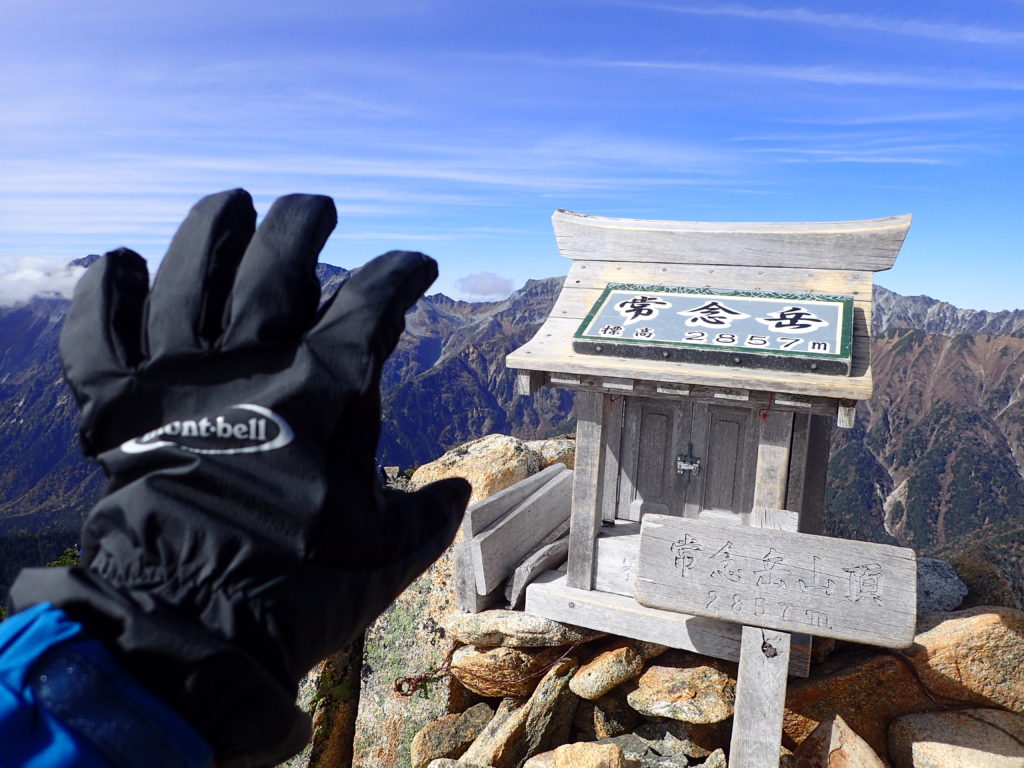 常念岳山頂でモンベルの登山用グローブであるサンダーパスグローブの記念撮影