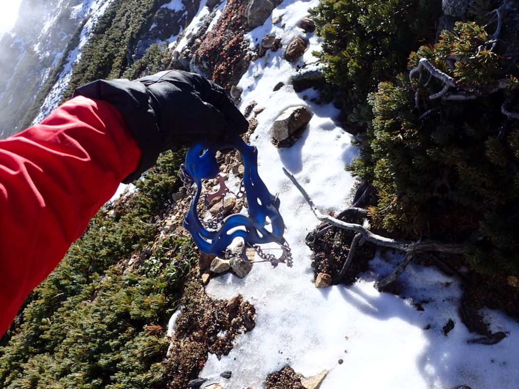 大天井岳の山頂直下で登山道に雪が着き始めたのでチェーンスパイクを装着準備