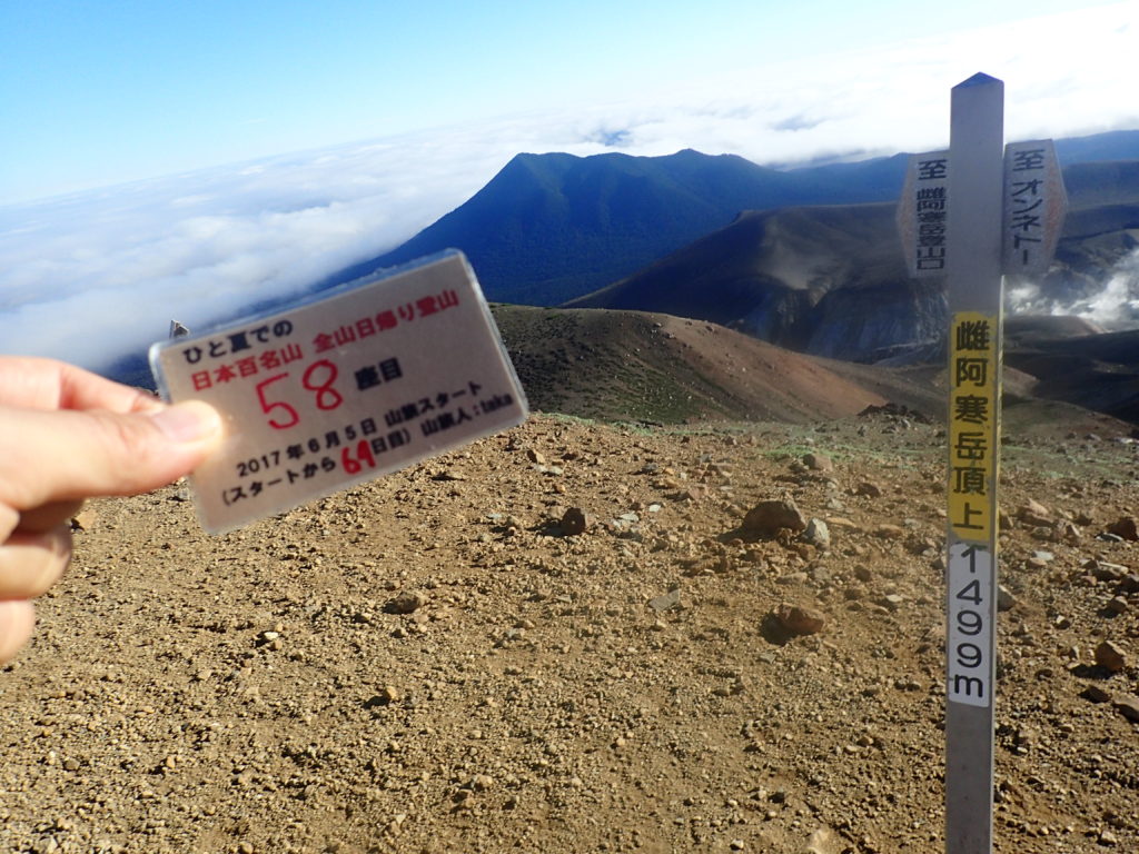 ひと夏での日本百名山全山日帰り登山で登った雄阿寒岳の山頂で自作の登頂カードで記念写真