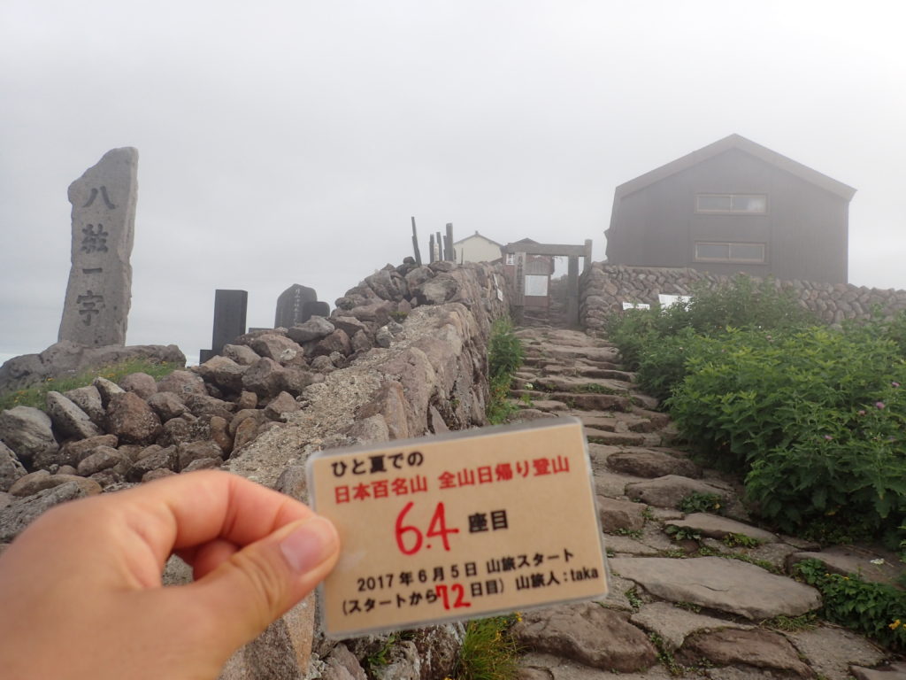 ひと夏での日本百名山全山日帰り登山で登った月山の山頂で自作の登頂カードで記念写真