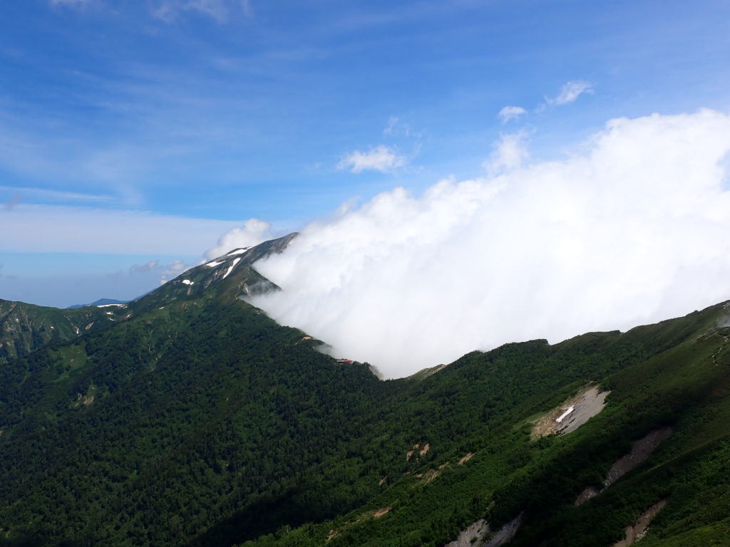 北アルプスの爺ヶ岳からオリンパスの防水デジタルカメラタフで撮影した、鹿島槍ヶ岳へと続く稜線が雲をせき止めている様子