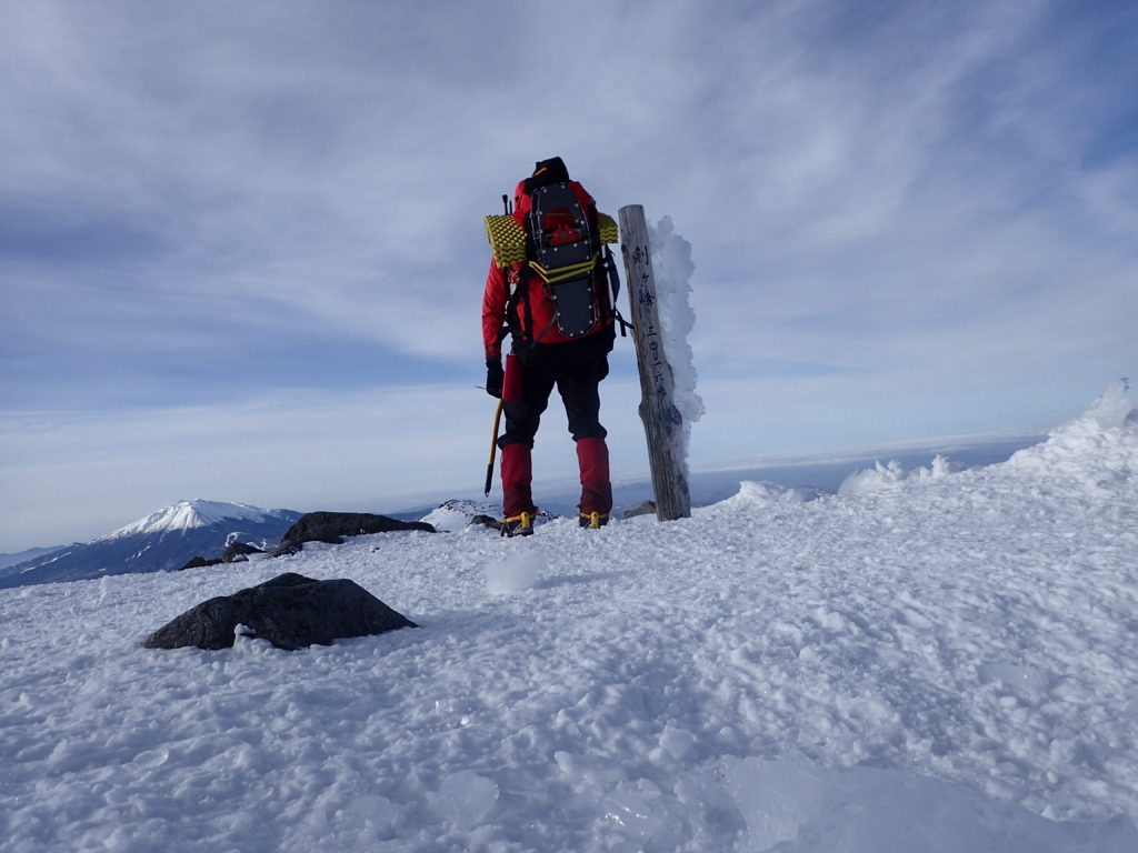 冬の北アルプス乗鞍岳登山の時にオリンパスの防水デジタルカメラタフで撮影した山頂でのザックを背負っての記念写真