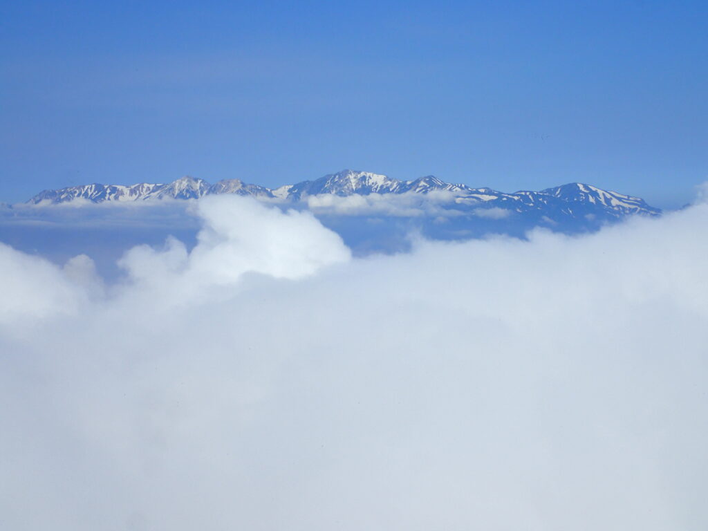 日本百名山の高妻山を登山した時にオリンパスの防水デジタルカメラタフで撮影した雲の向こうの白馬三山