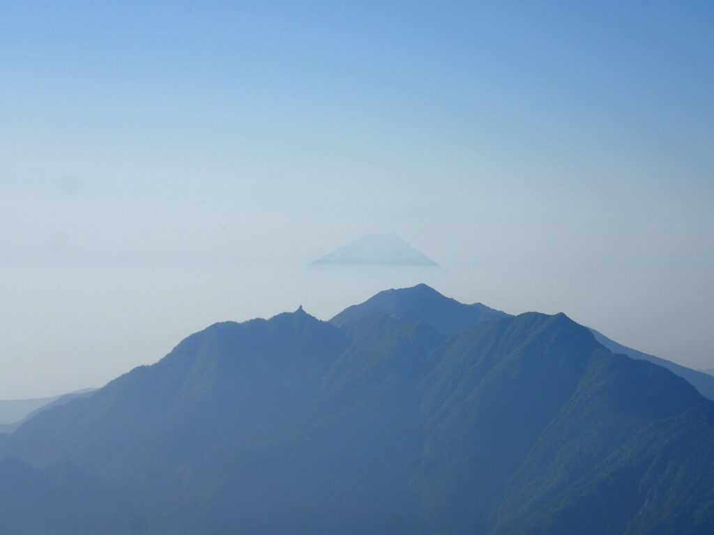 日本百名山で南丸プ巣の甲斐駒ヶ岳を登山した時にオリンパスの防水デジタルカメラタフで撮影した鳳凰三山の向こうの富士山