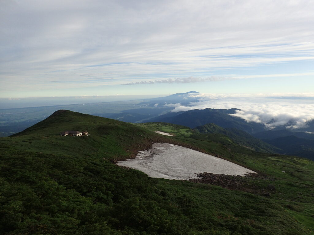 日本百名山の月山を登山した時にオリンパスの防水デジタルカメラタフで撮影した佛生池小屋と残雪と雲海と鳥海山